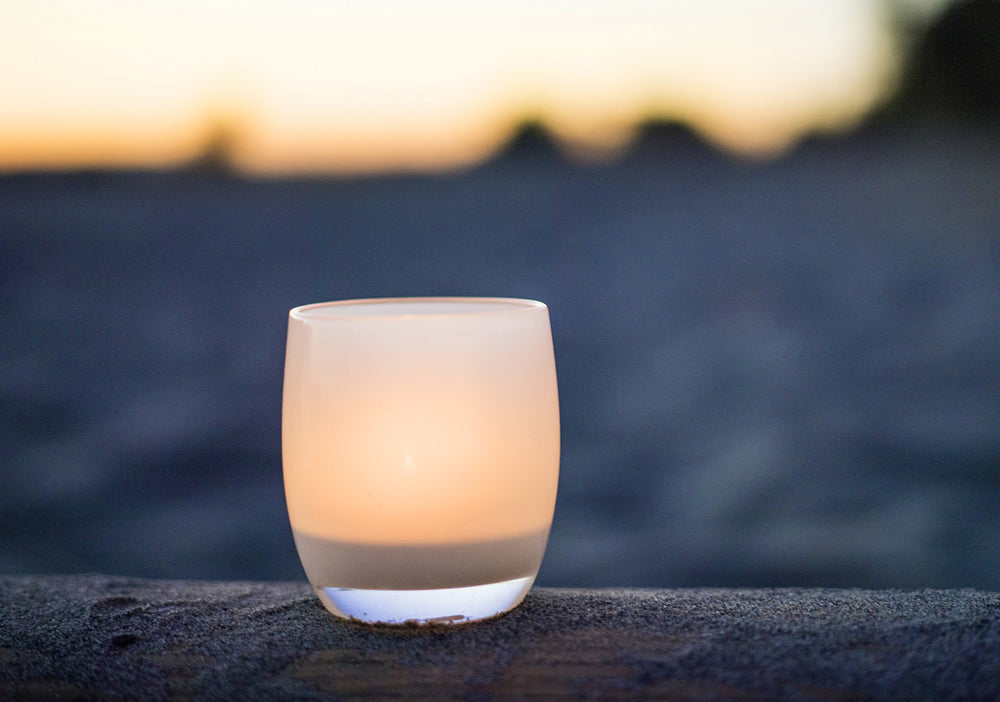 'kindness' glassybaby on wood log at dusk