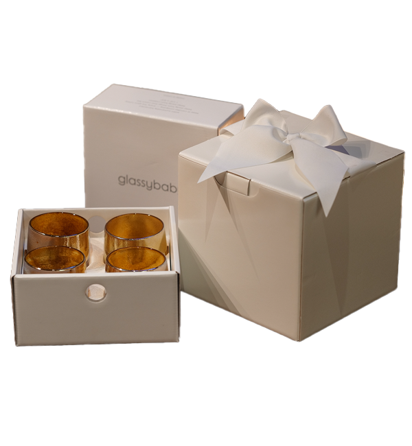 four hundred hours gift box, one hundred palm wax tea lights, and four hand-blown glass votives candle holders, together in a bowed white box