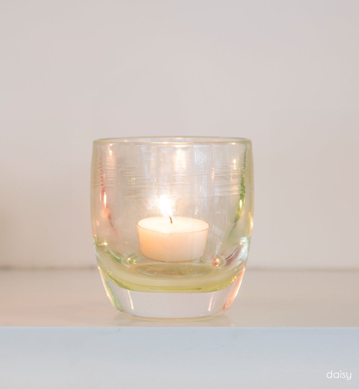 petunia transparent light pink hand-blown glass votive candle holder on white shelf