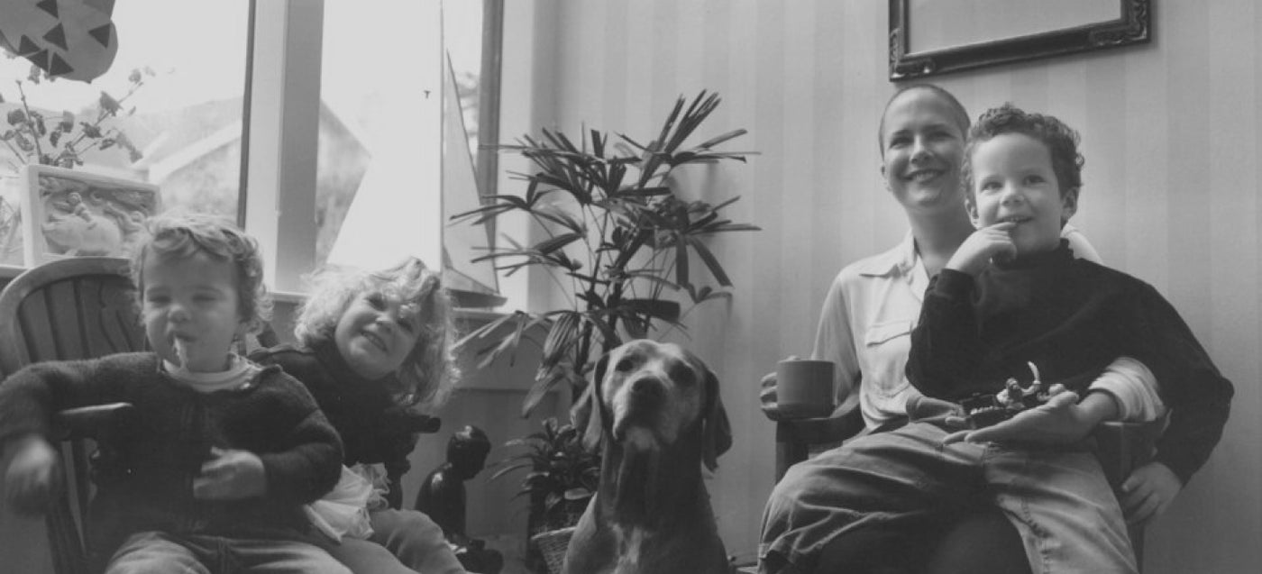 black and white photo of Lee Rhodes sitting with dog and small children