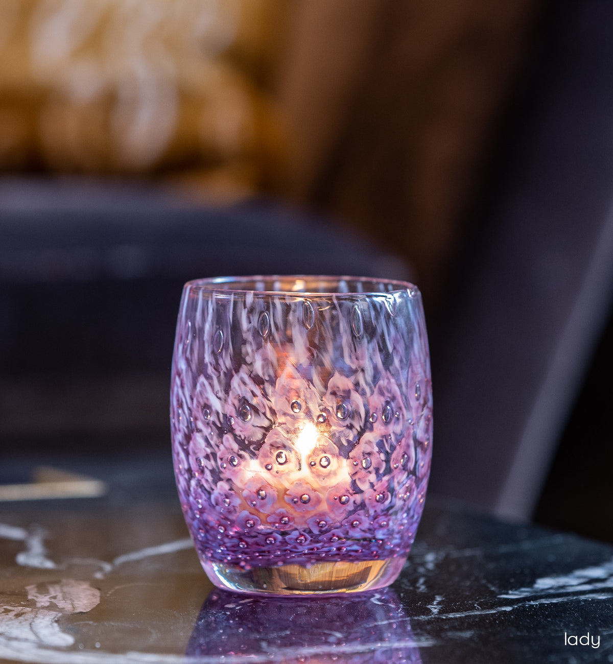 lady purple bubble, hand-blown glass votive candle holder on a marble living room table.