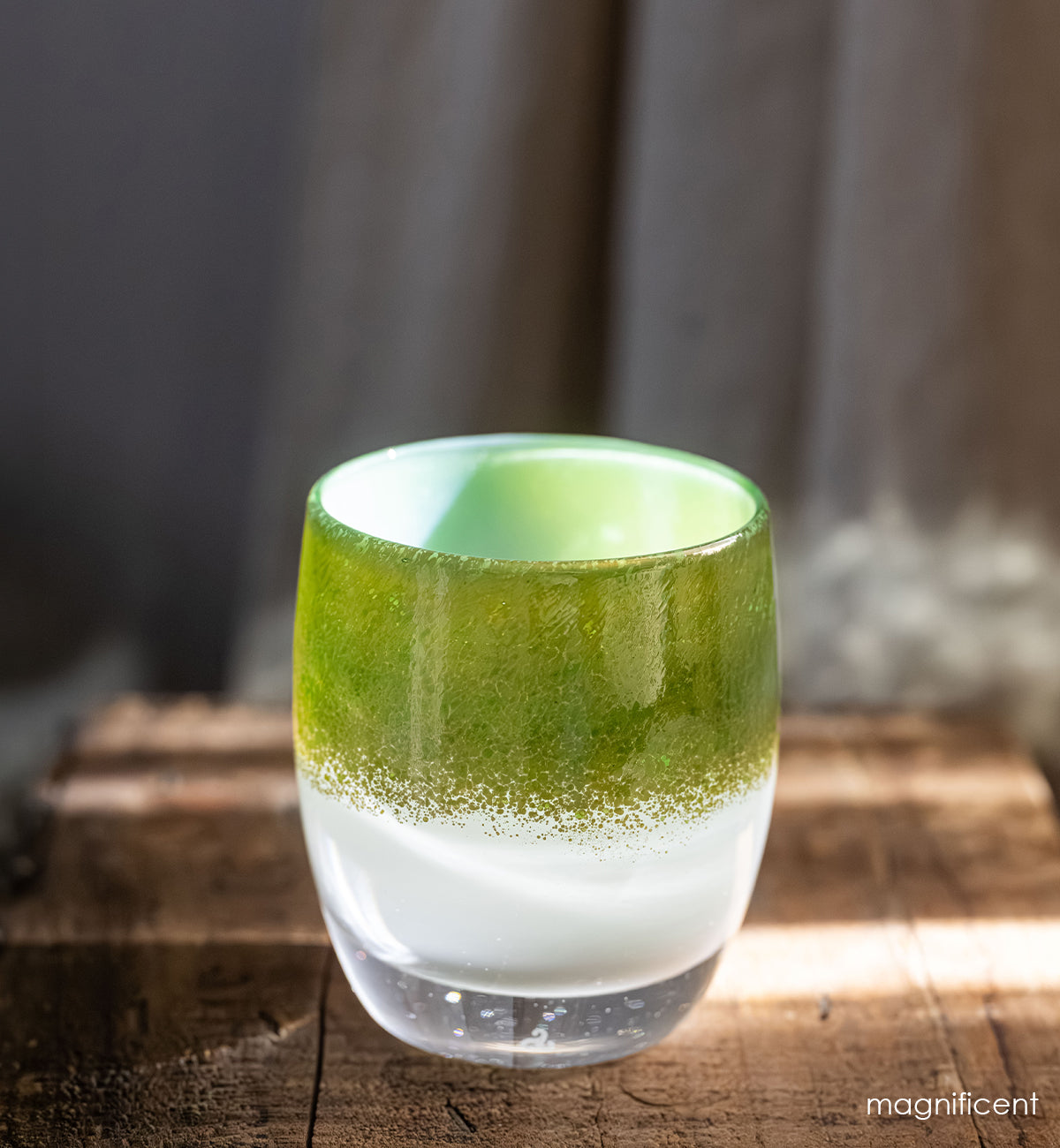 magnificent green and gold tones cover a white base, hand-blown glass candle holder.