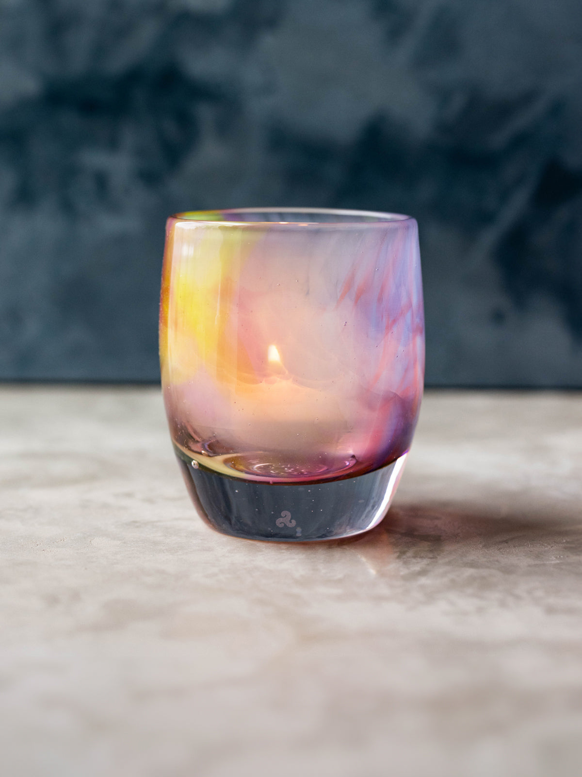 make a wish glassybaby, a multi-color hand-blown candle holder on gray table with white background
