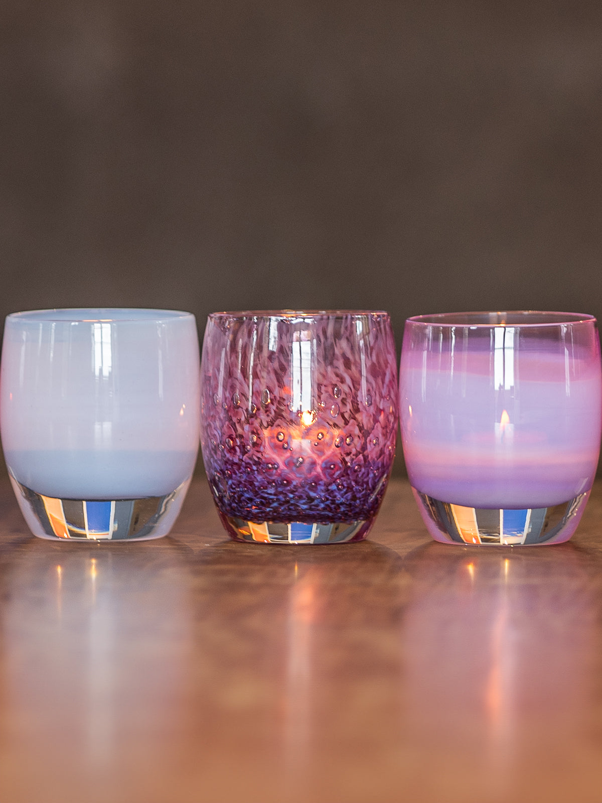 mother's day collection glassybaby hand-blown glass candle holders on wood bench.