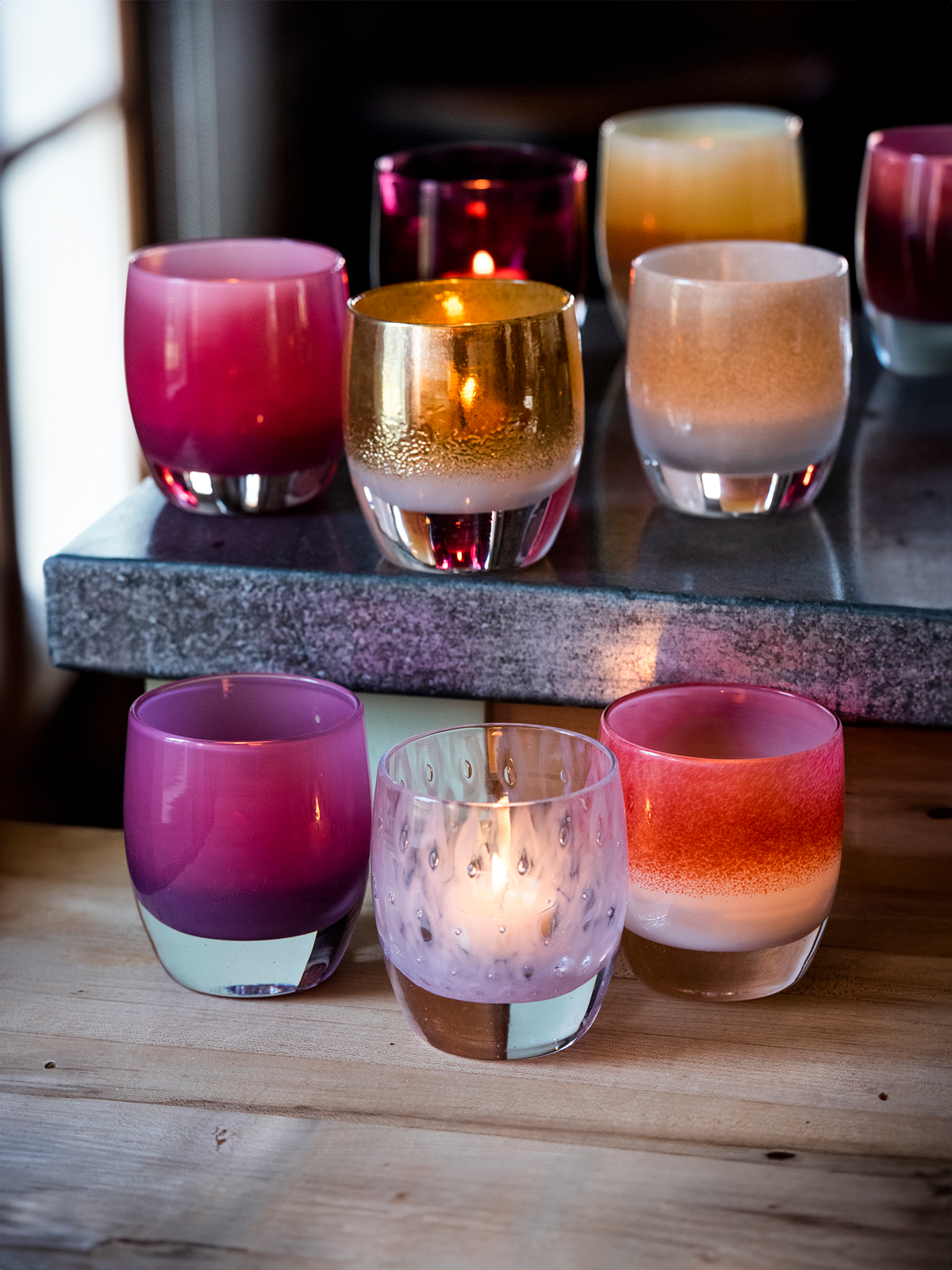 mother's day collection glassybaby hand-blown glass candle holders on wood bench.
