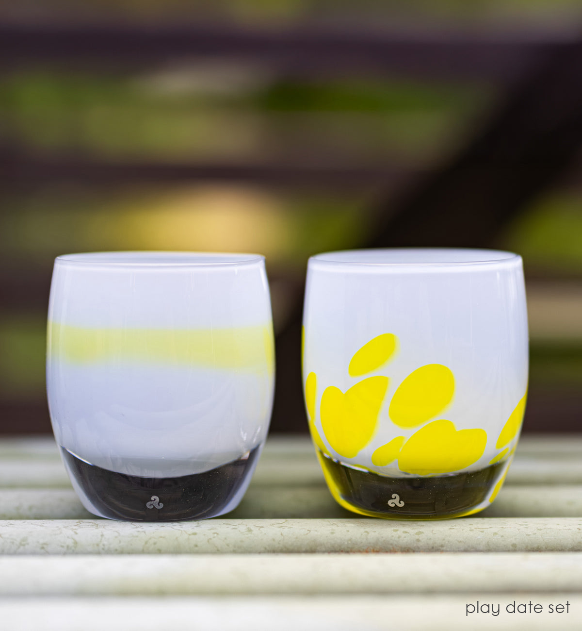 light blue and yellow chartreuse and light blue with yellow petals set of two hand-crafted glass votive candle holders lit with outdoor background