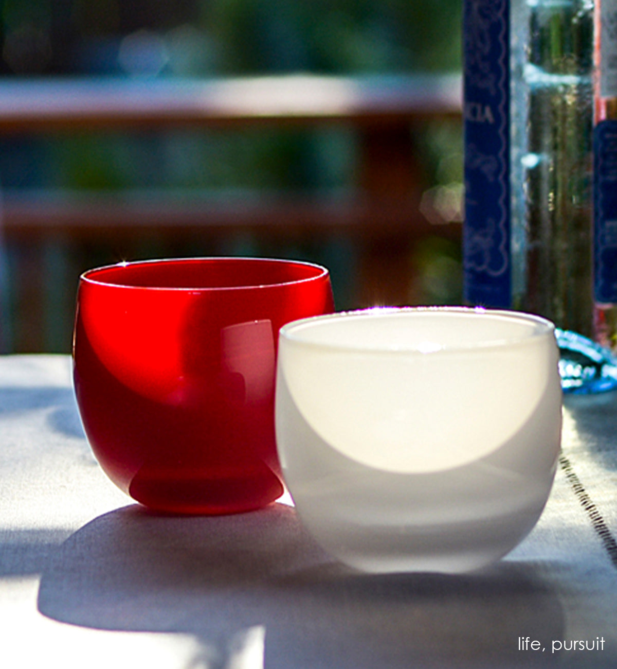 pursuit drinker, stark white hand-blown drinking glass paired with life drinker on a countertop next to a window.