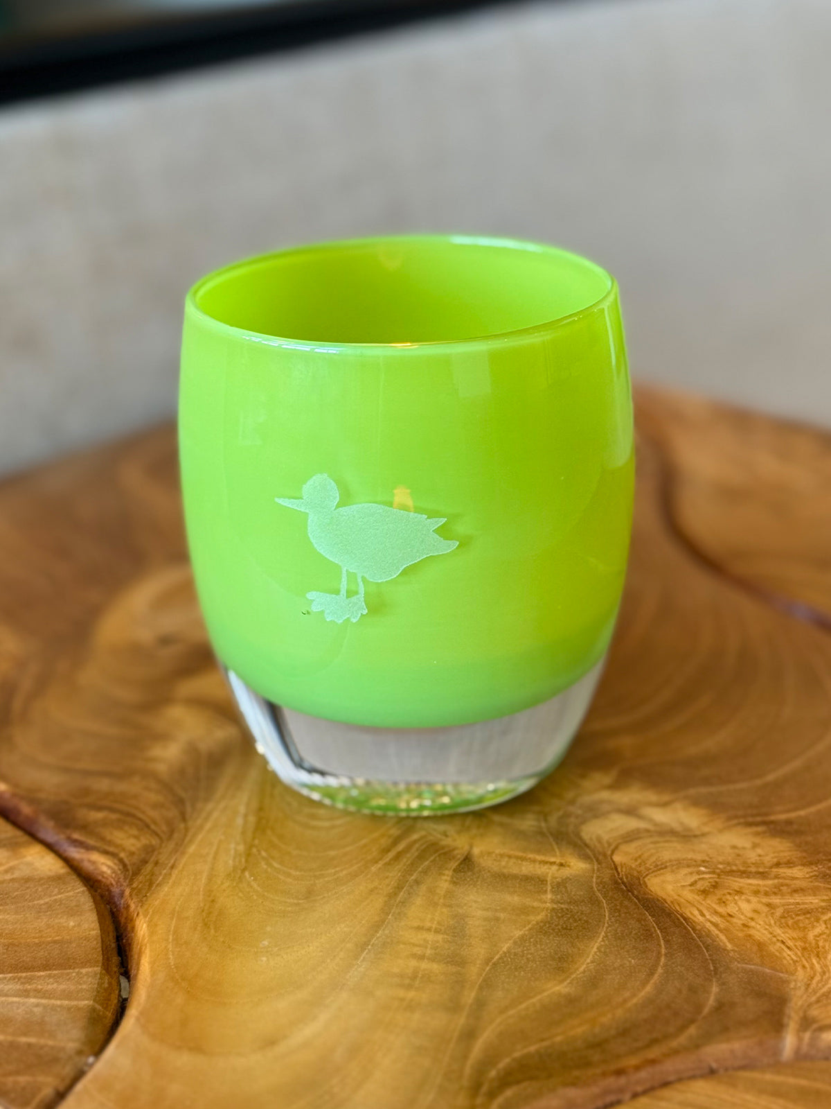 green glass candle holder with hand etched seagull on wood surface