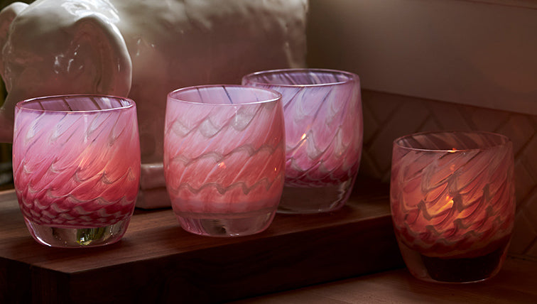 harmony, a white and pink patterned hand-blown glass candle holder sitting on a kitchen countertop.