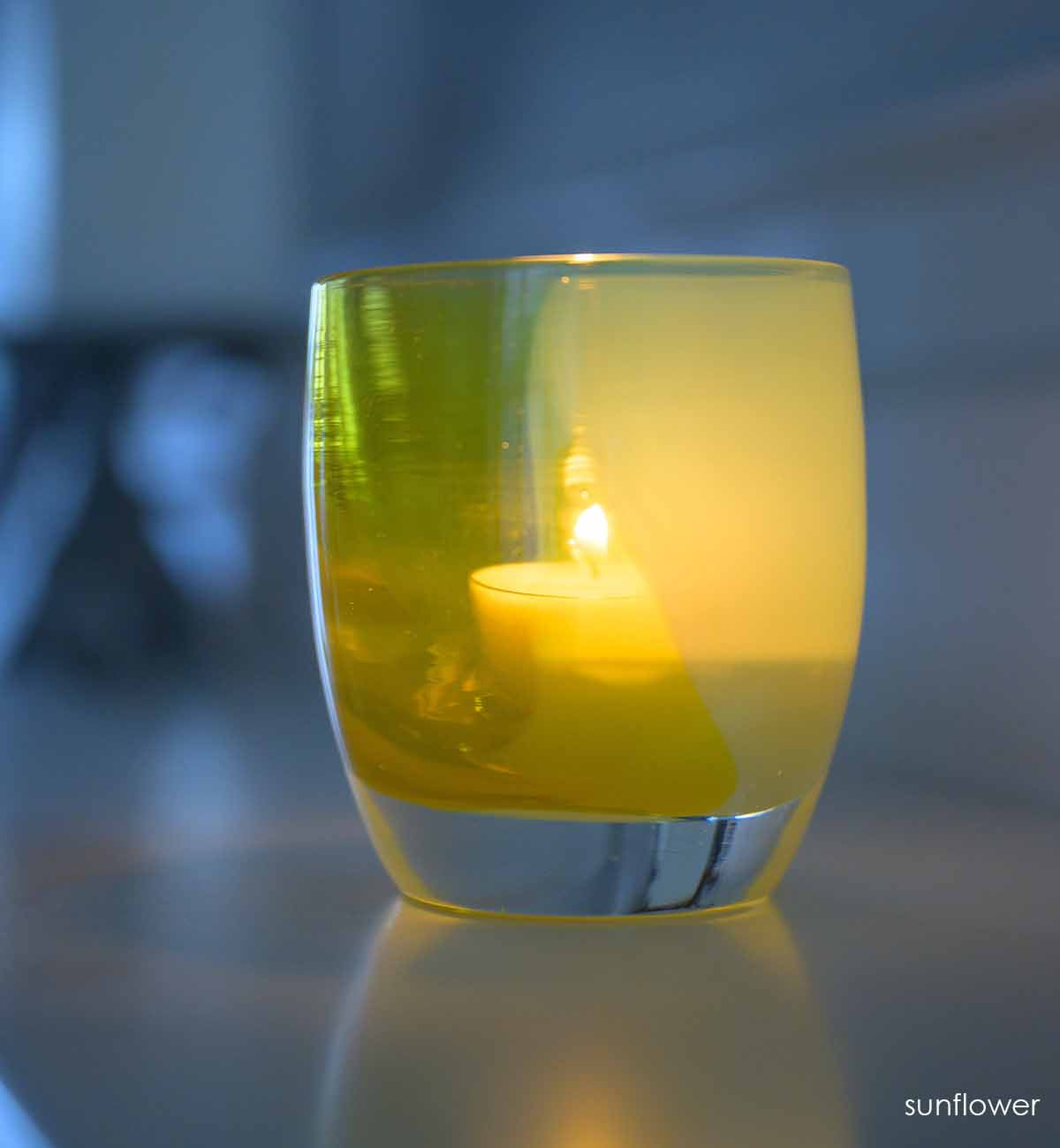 sunflower votive glowing on a mantel.