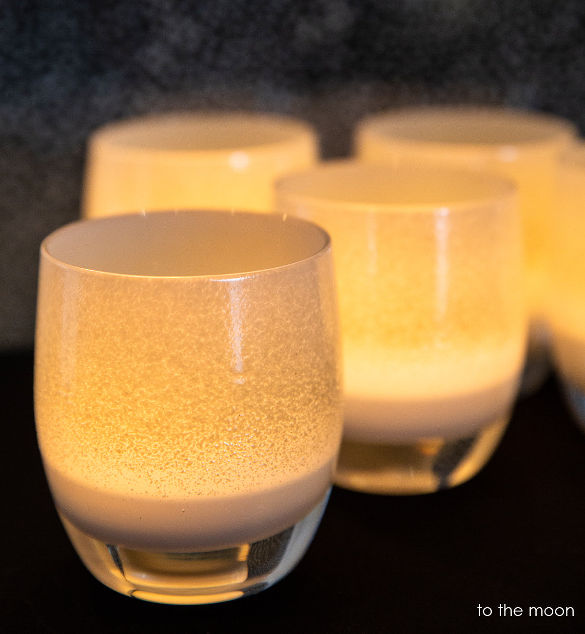 group of to the moon light grey and white, hand-blown glass votive candle holders.