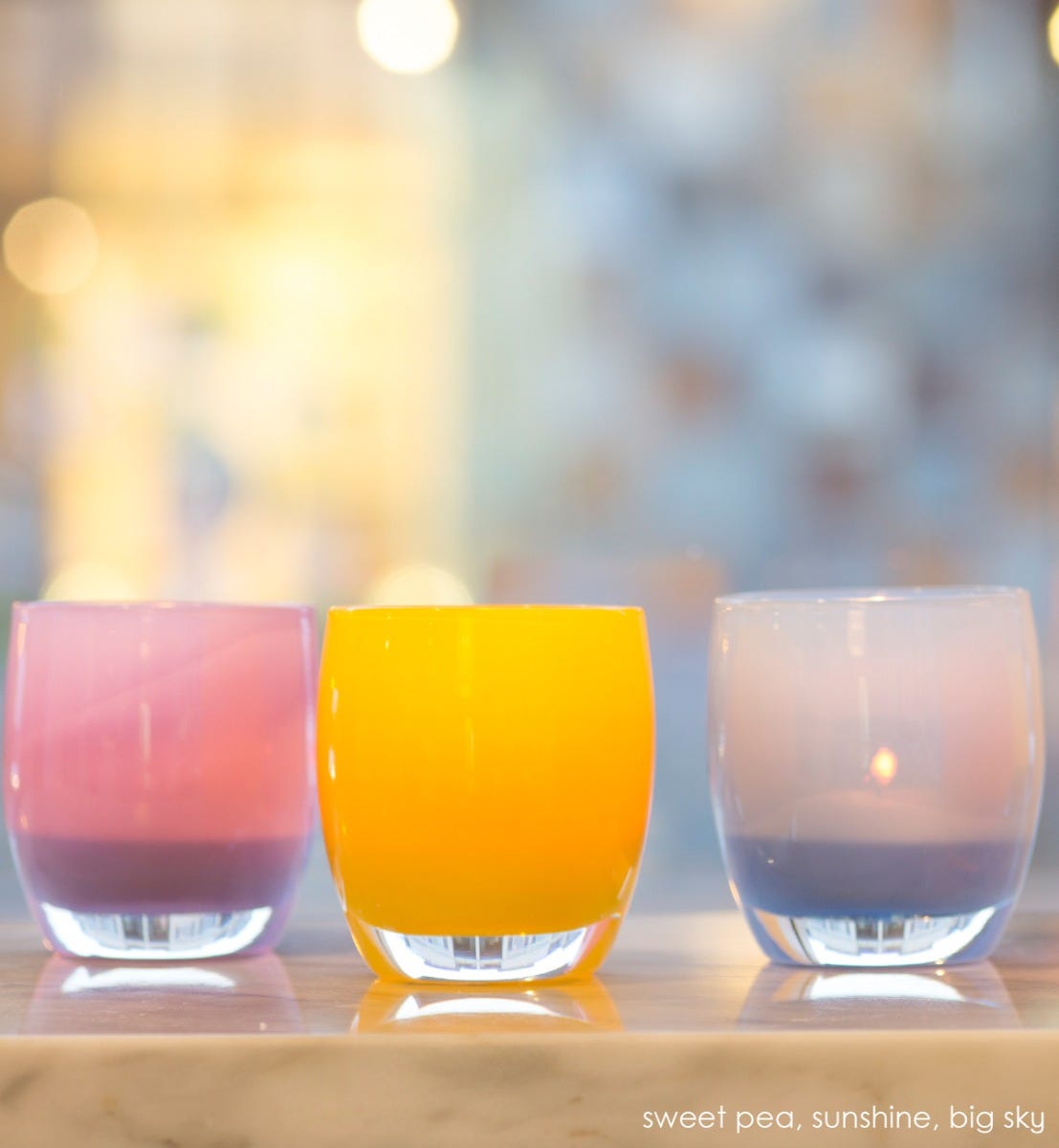 big sky, opaque sky blue, hand-blown glass votive candle holder. paired with sweet pea and sunshine on marble counter.