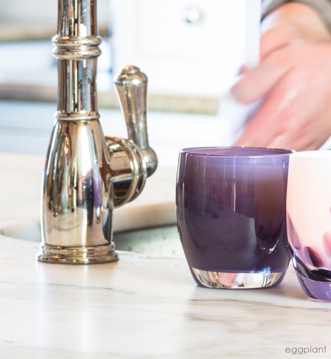 eggplant glass hand-blown glass votive candle holder. Paired with wisteria next to a kitchen sink.