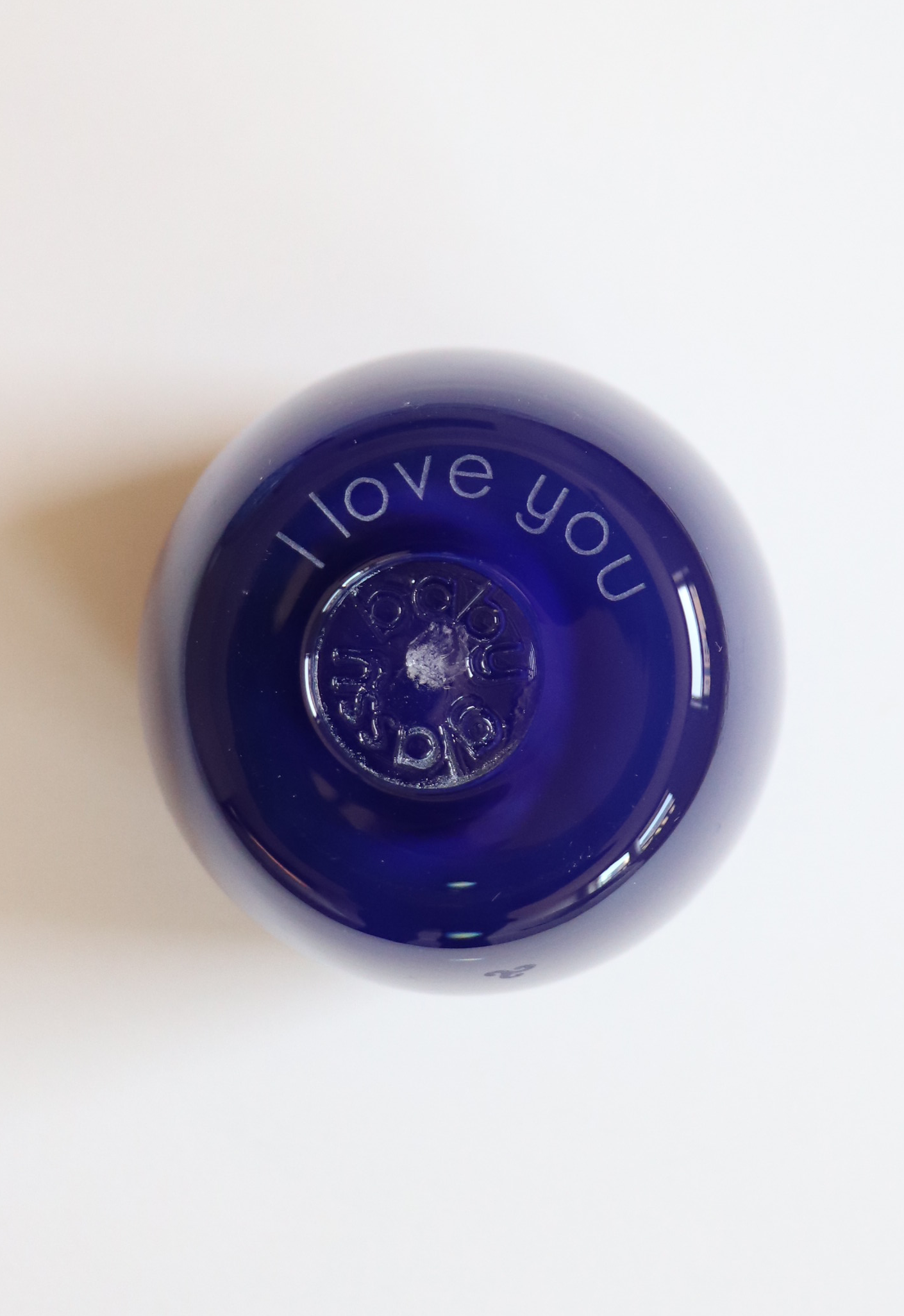 "i love you" etched on the bottom of a hand-blown glass votive candle holder