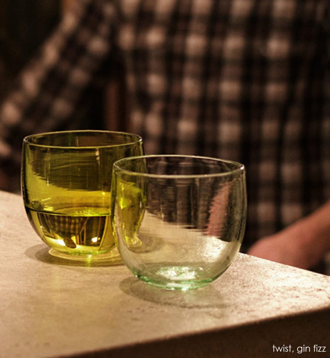 gin fizz drinker, transparent light green hand-blown drinking glass. Paired with twist.