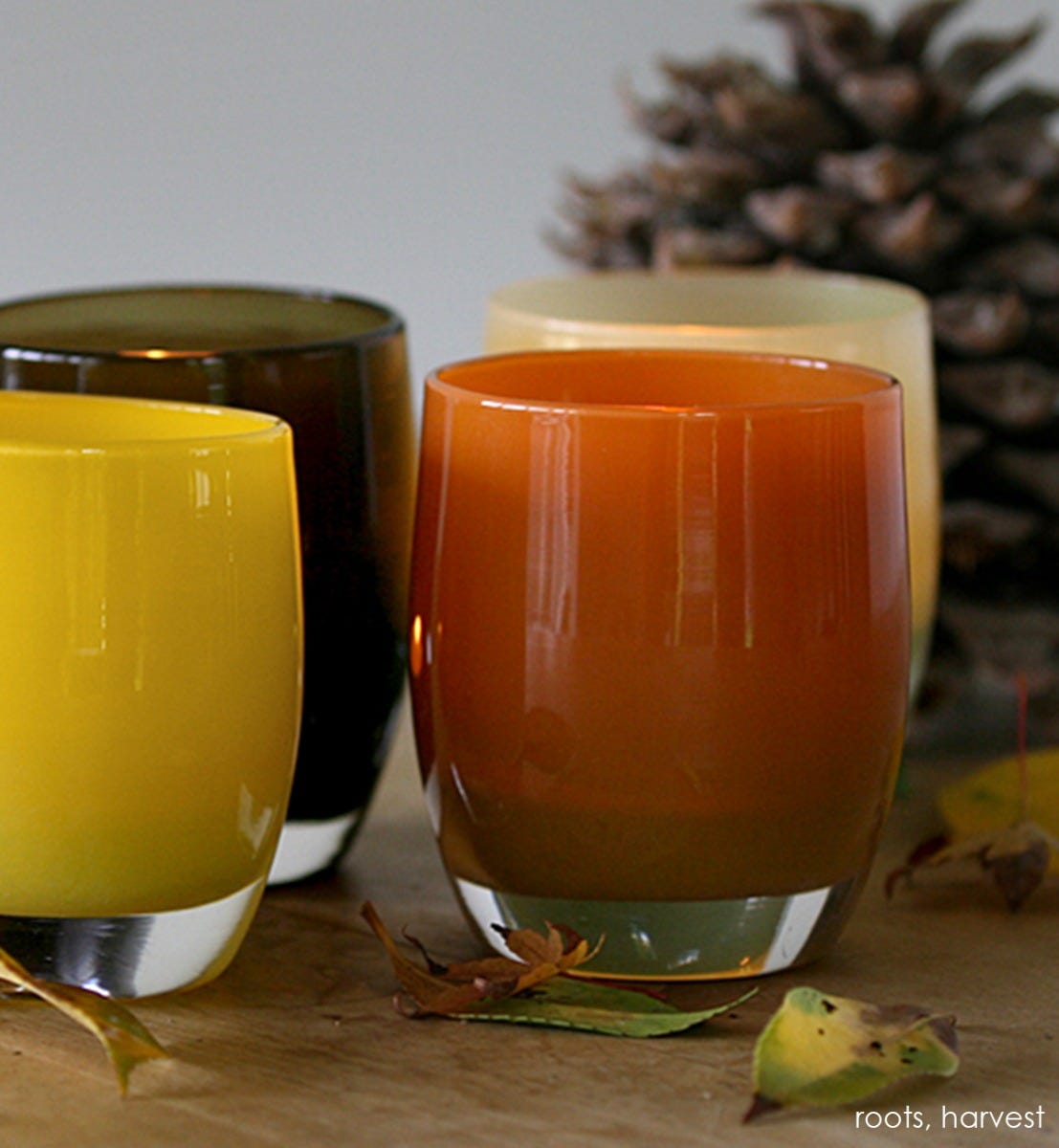 harvest deep orange hand-blown glass votive candle holder. Paired with roots.