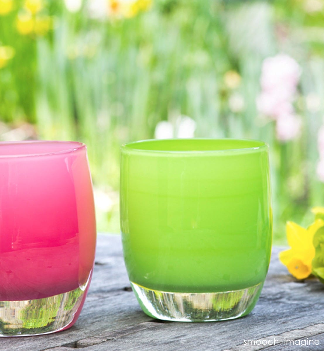 imagine, kashmir green, hand-blown glass votive candle holder. Paired with smooch on a wood picnic table with flowers around.