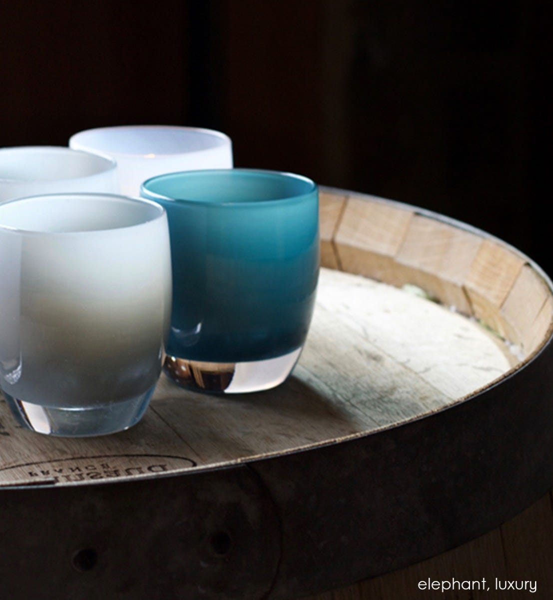 luxury turkish blue hand-blown glass votive candle holder. Paired with elephant atop a wood barrel.