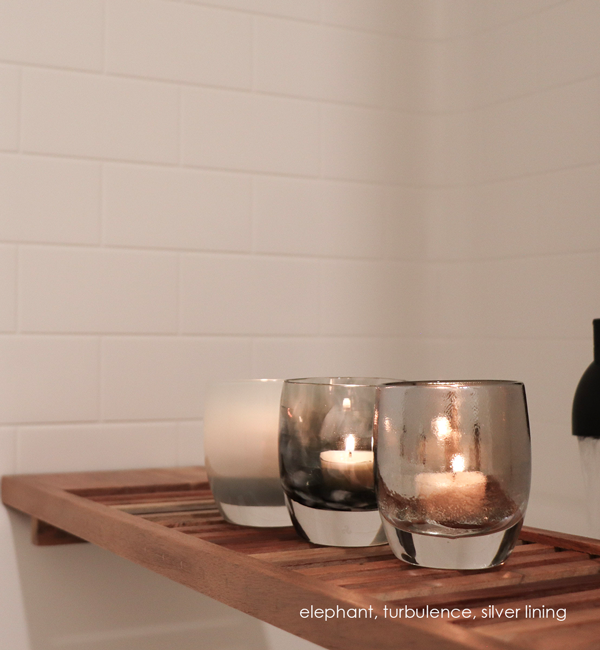 silver lining, chrome topped clear, hand-blown glass votive candle holder, paired with elephant and turbulence on a wood bathtub tray.
