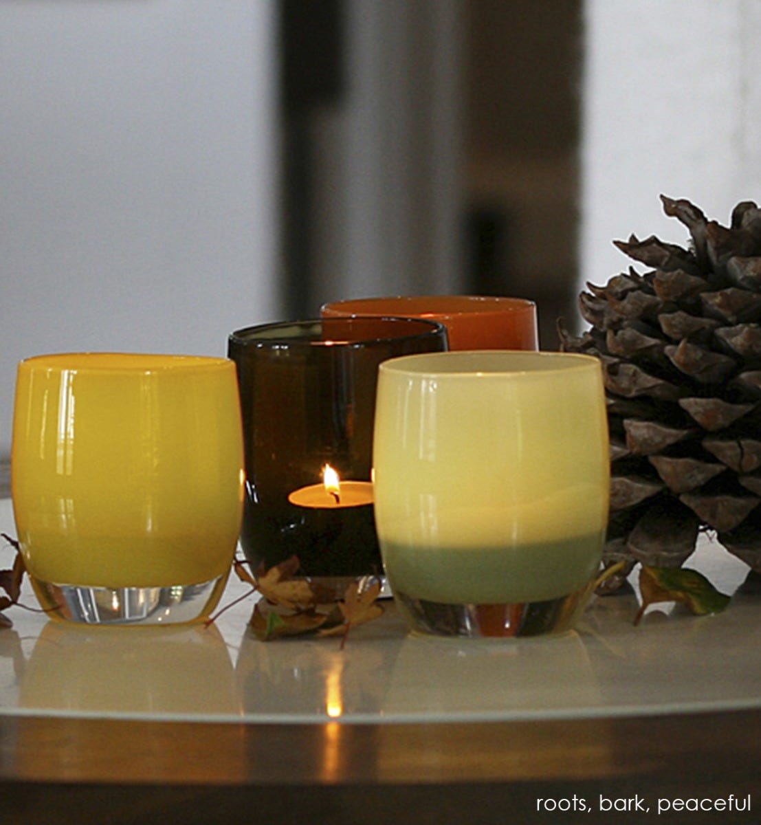 peaceful agate green hand-blown glass votive candle holder. Paired with roots and bark.