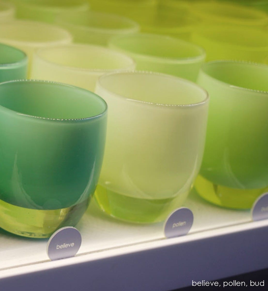 hand-blown off white glass votive candle holder with touch of green.