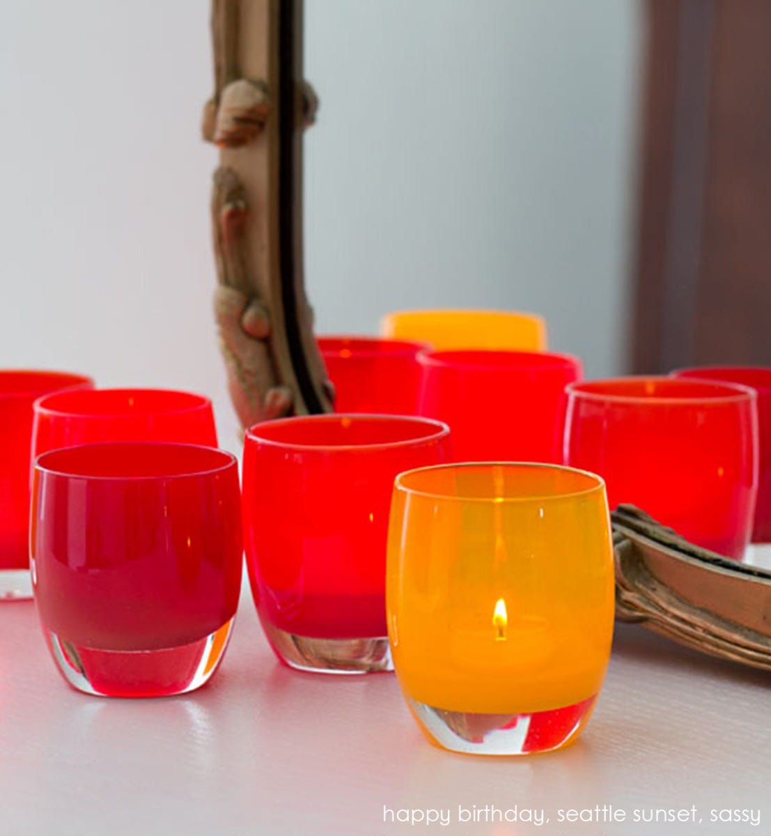 sassy bright orange yellow hand-blown glass votive candle holder. Paired with happy birthday and seattle sunset on a cream surface with rustic mirror.