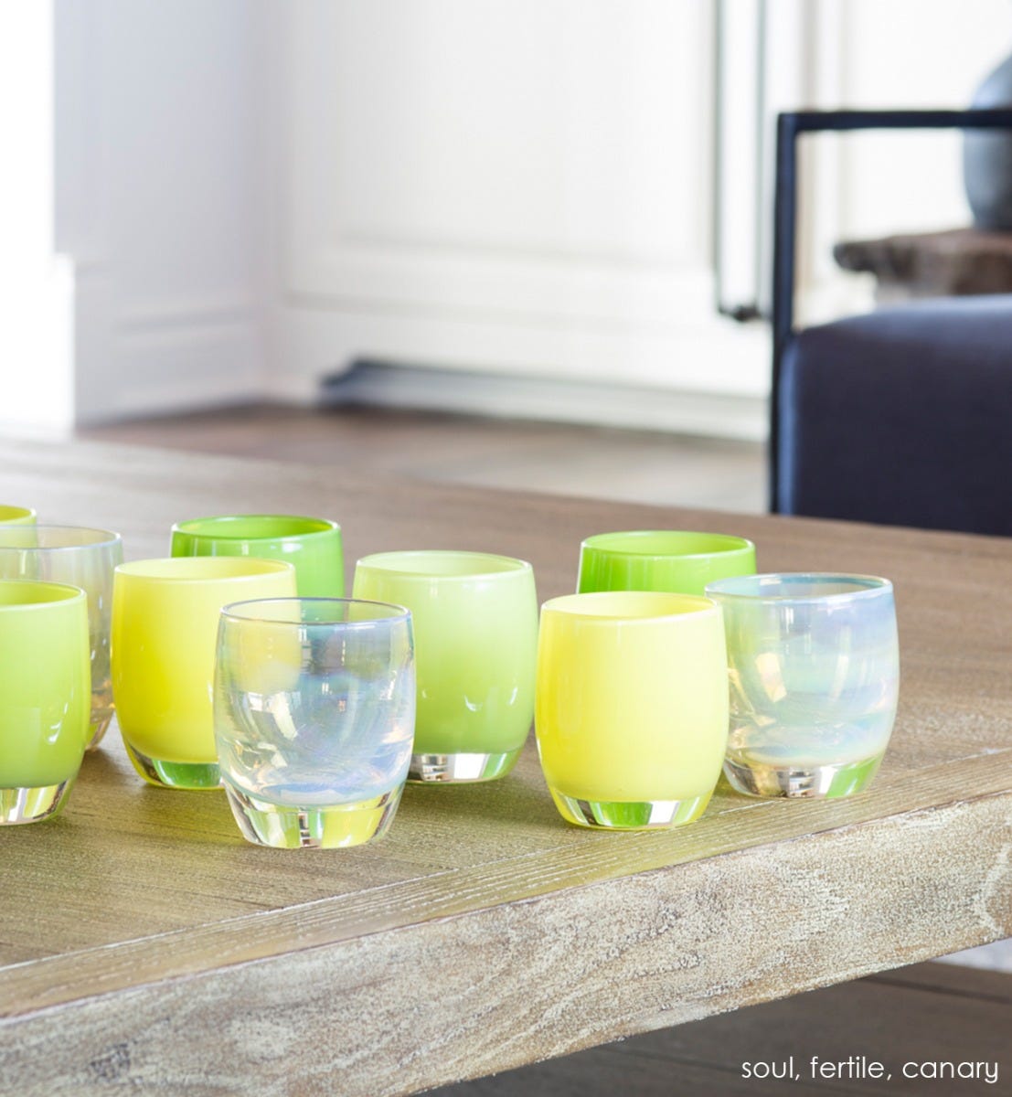 soul iridescent golden white hand-blown glass votive candle holders on a wood coffee table with fertile and canary.