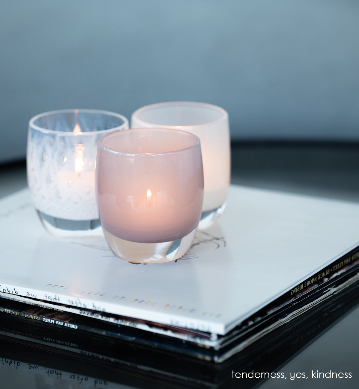 tenderness, a soft-purple hand-blown glass votive candle holder. paired with yes and kindness on a stack of records.