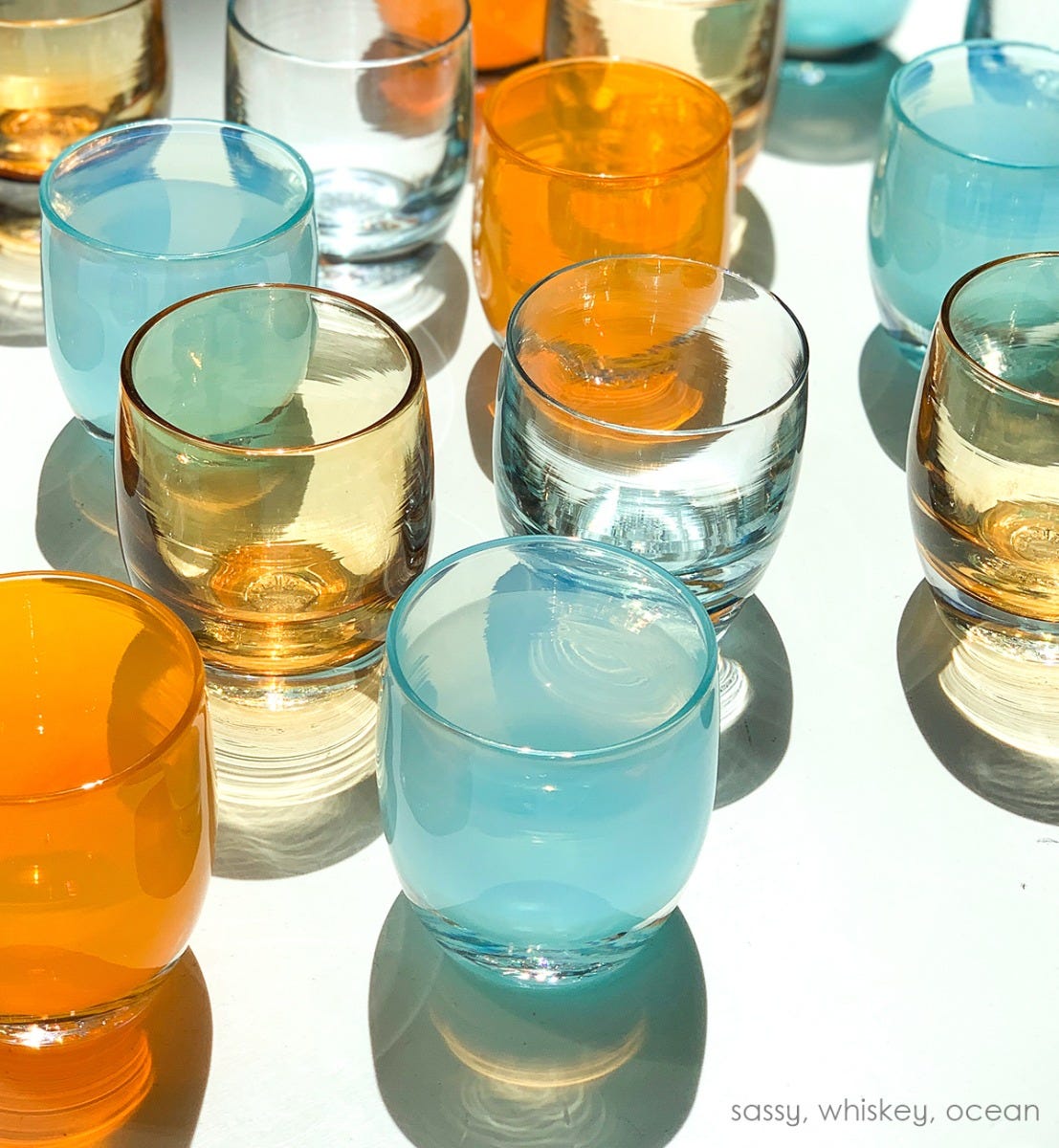 whiskey, transparent light amber, hand-blown glass votive candle holder. Paired with sassy and ocean on a white outdoor table