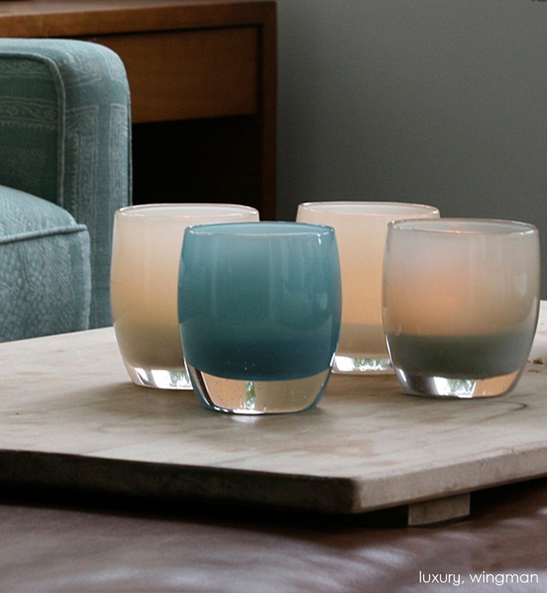 wingman, harbor gray, hand-blown glass votive candle holders with luxury on a wood tray on a living room leather ottoman.