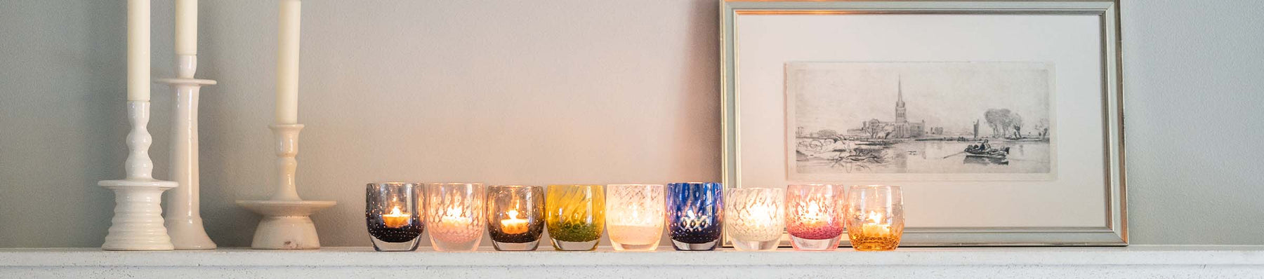 a collection of hand blown votives with bubbles in various colors