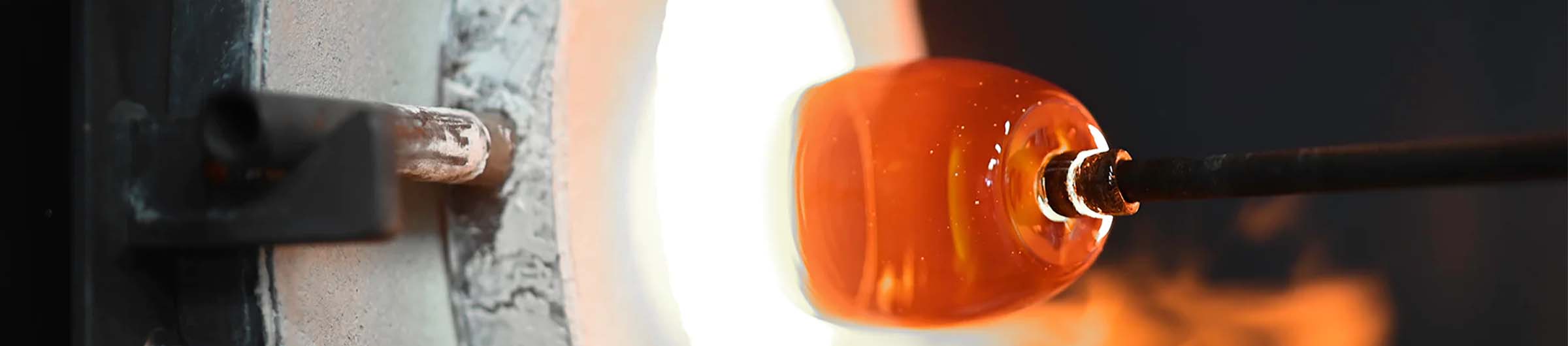 glassybaby in hot shop process: crafting a hand-blown glass votive candle holder in front of a furnace.