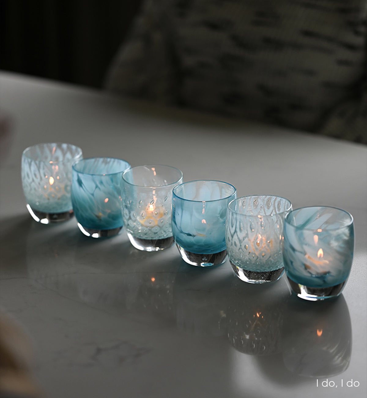 three sets of i do, i do lined up and lit on a marble kitchen table.