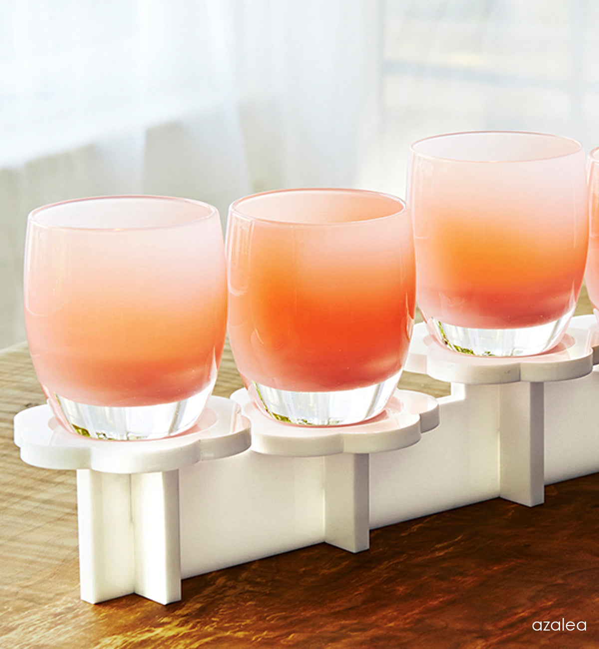 azalea light pink hand-blown glass votive candle holders on on white stand.