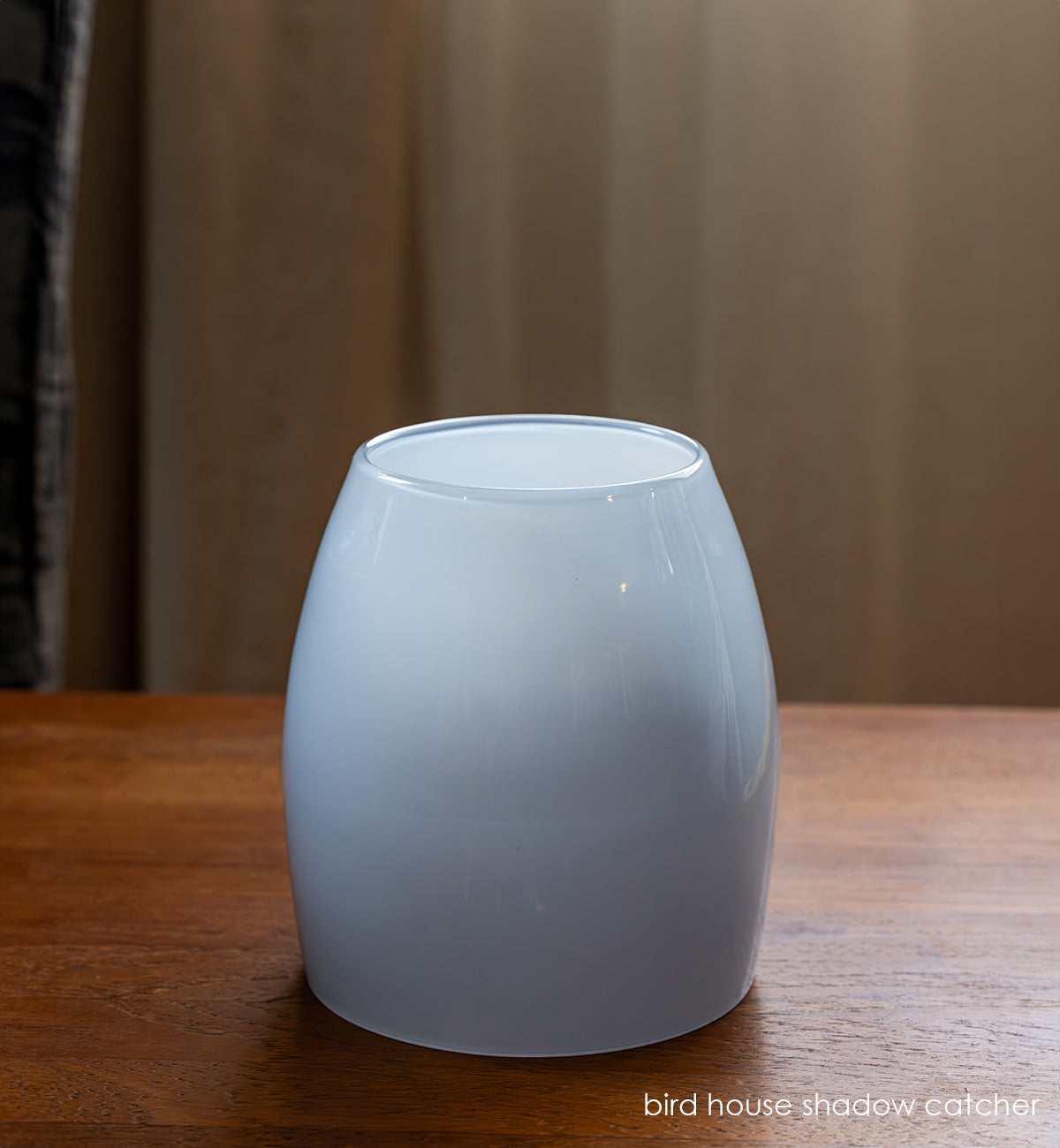 hand-blown glass cover 'shadow catcher' on wooden surface