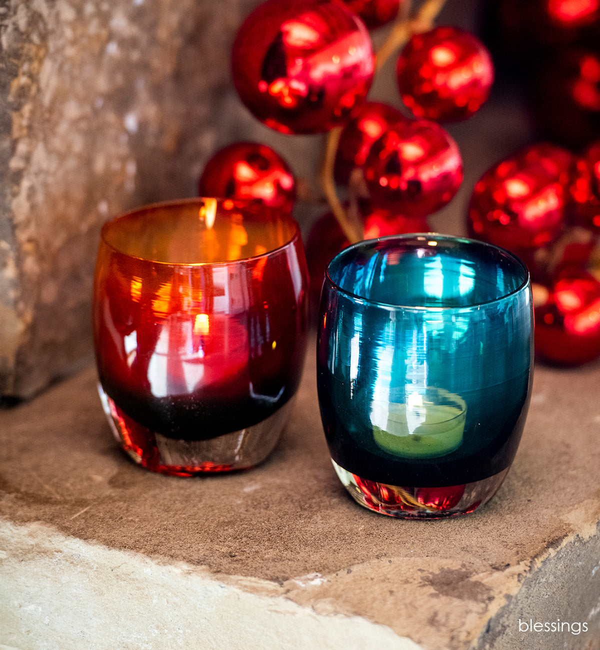 blessings holiday set grateful red gratitude red green hand-blown glass votive candle holder sitting in front of some red christmas ornaments.