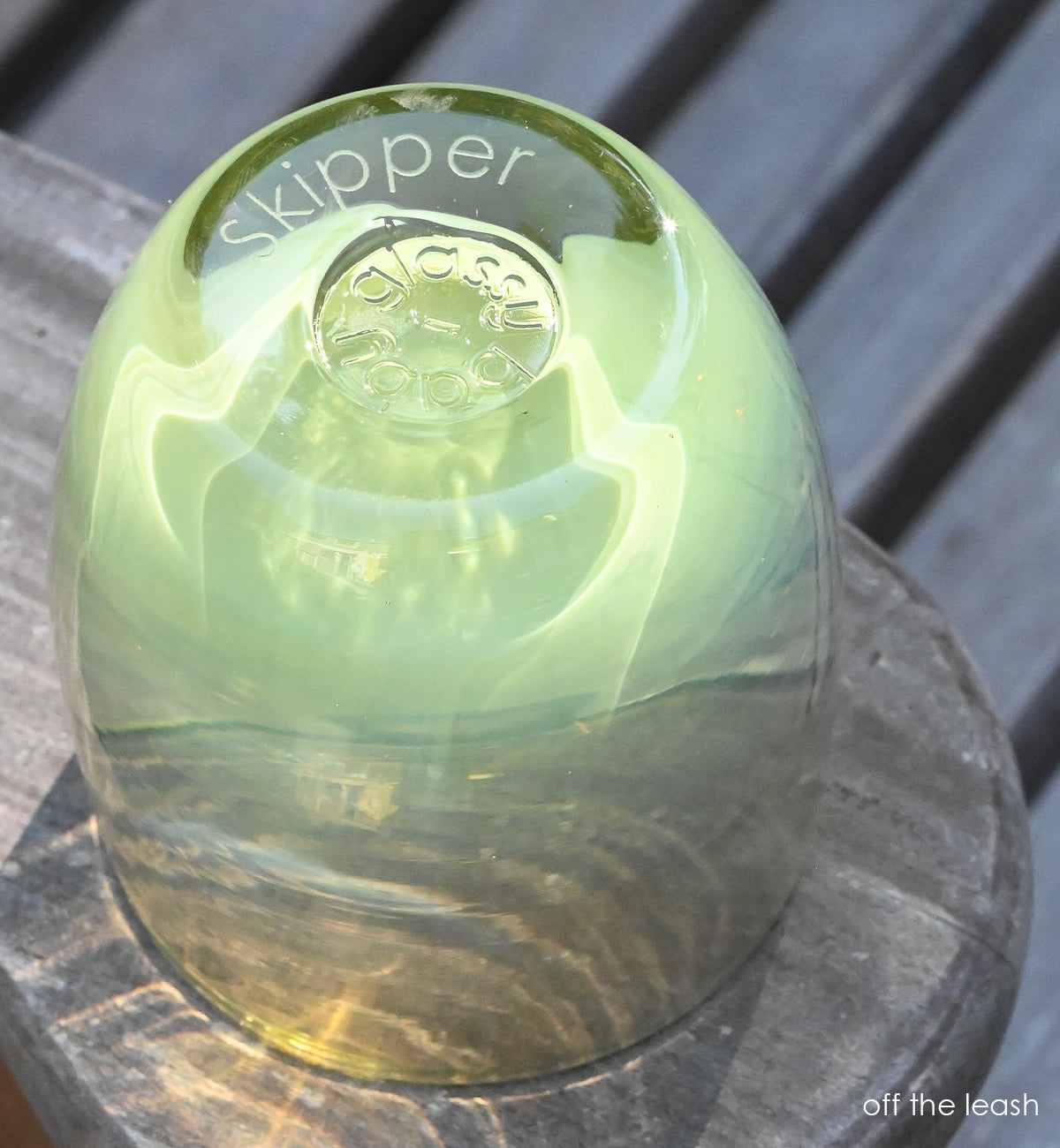 green hand-blown glass votive candle holder upside down with "skipper" etched into the bottom