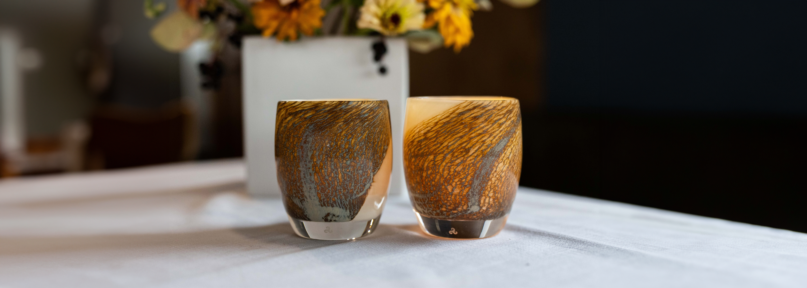 two dream land, cream with brown textured swirls hand-blown glass votives glassybaby  with fall flowers in the background.