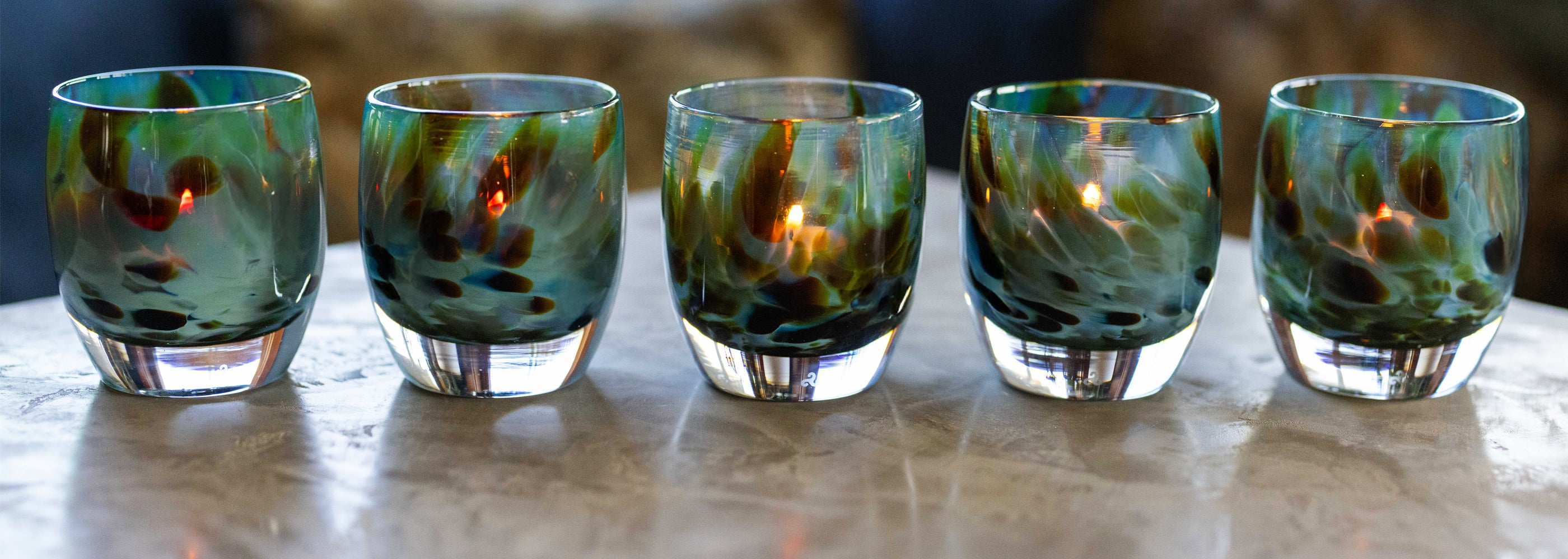 equinox glassybaby, teal and brown hand-blown glass candle holders sitting on table