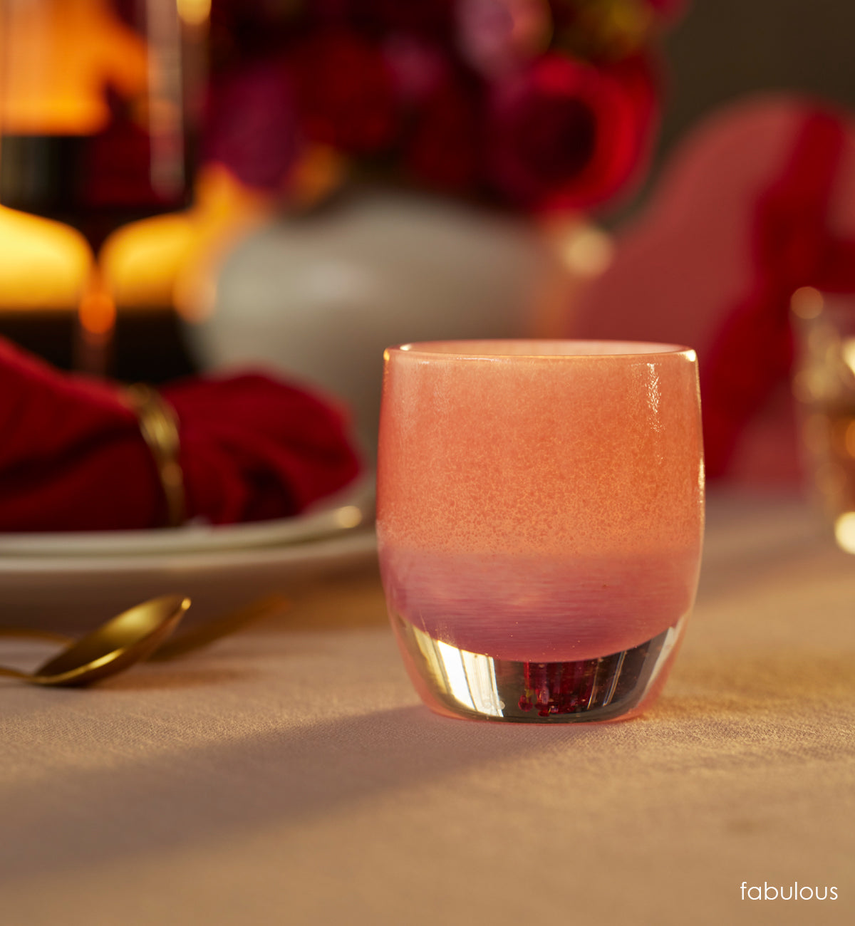 one fabulous, pink textured hand-blown glass votive candle holders on a dining room table.