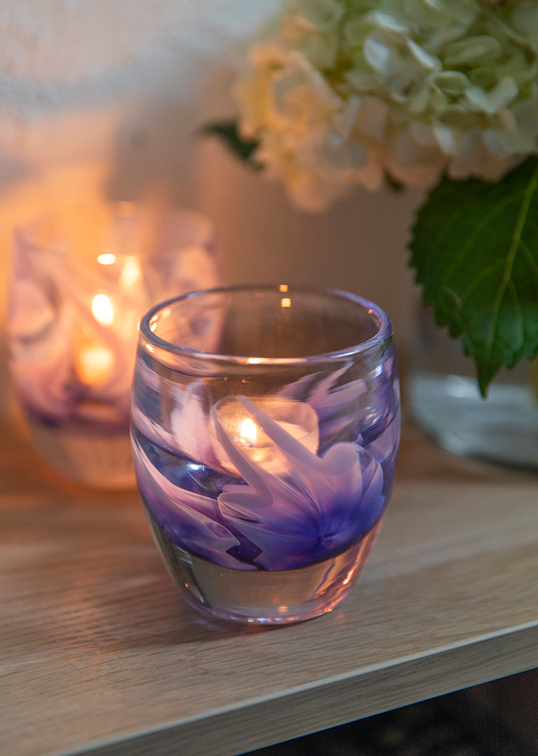 purple murrini flowers on a clear hand-blown class candle holder. flowers for loved ones that will last forever.