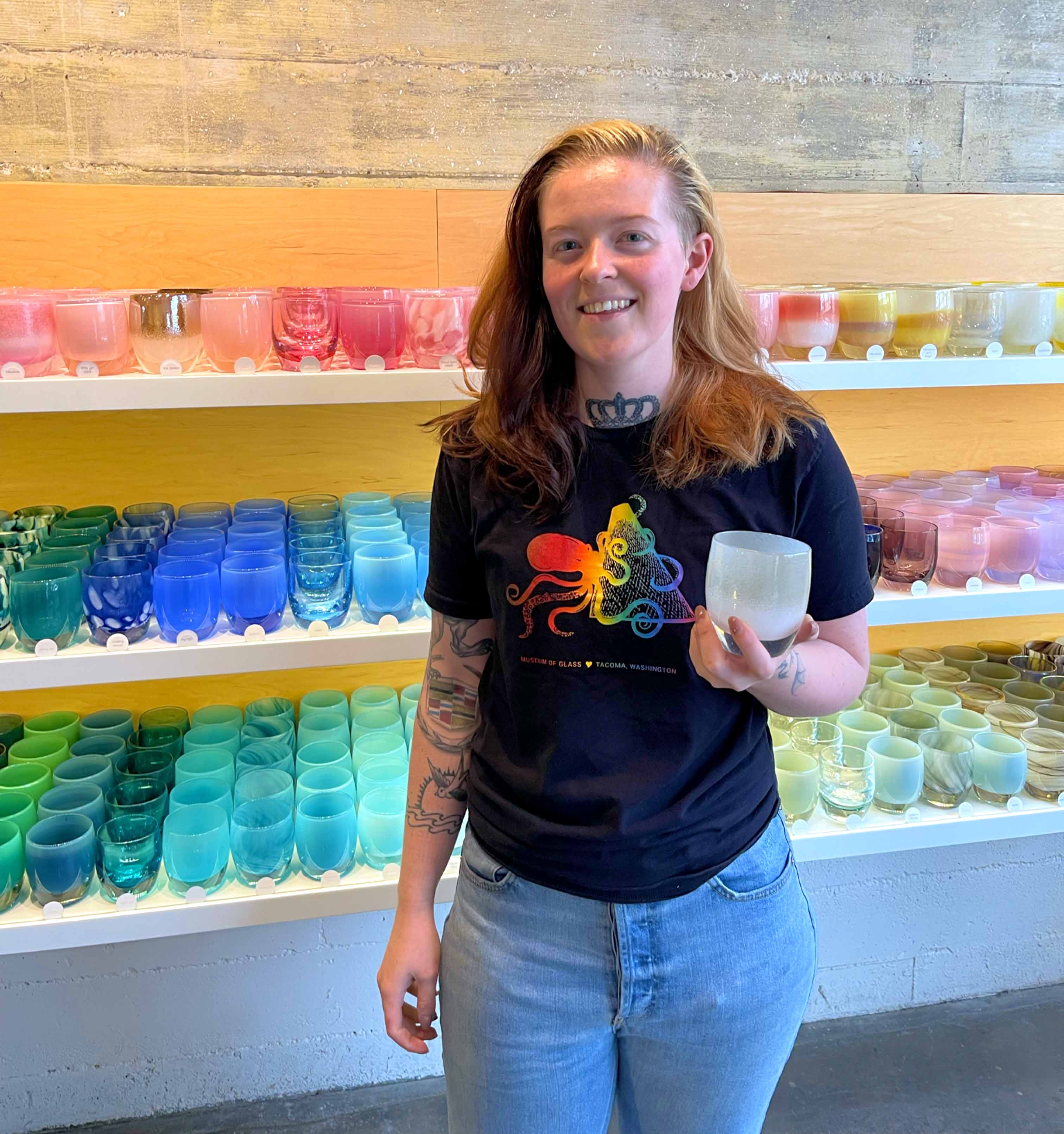 glassblower Karlie standing in store with her favorite glassybaby 'to the moon'