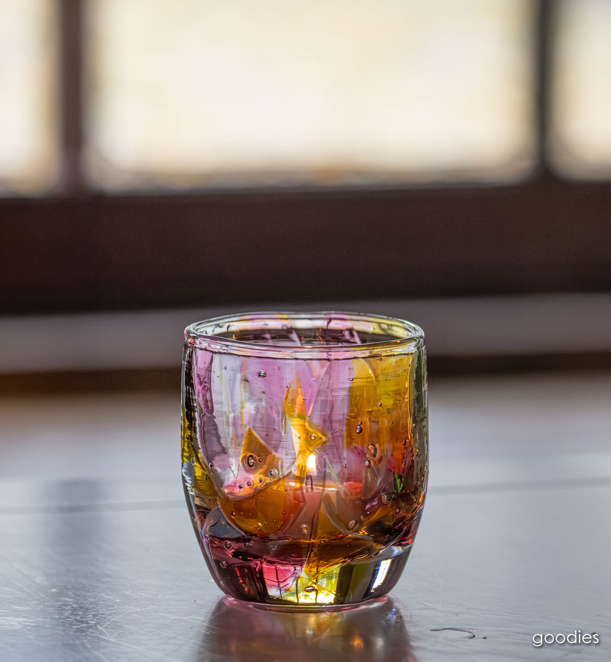 goodies glassybaby, pink and yellow shards melted into clear hand-blown glass candle holder window light shining through.