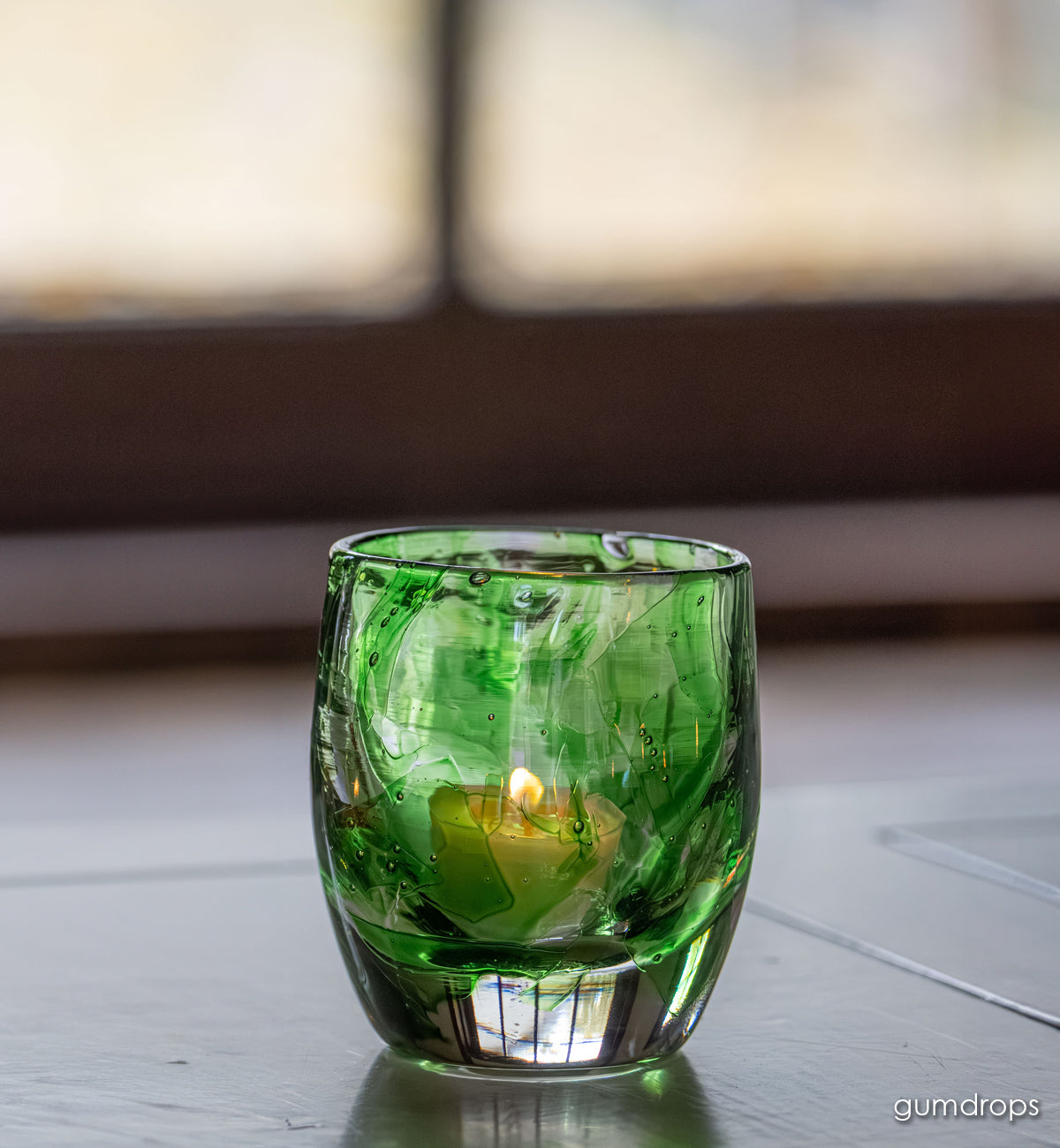 gumdrops glassybaby, green shards melted into clear hand-blown glass candle holder window light shining through.