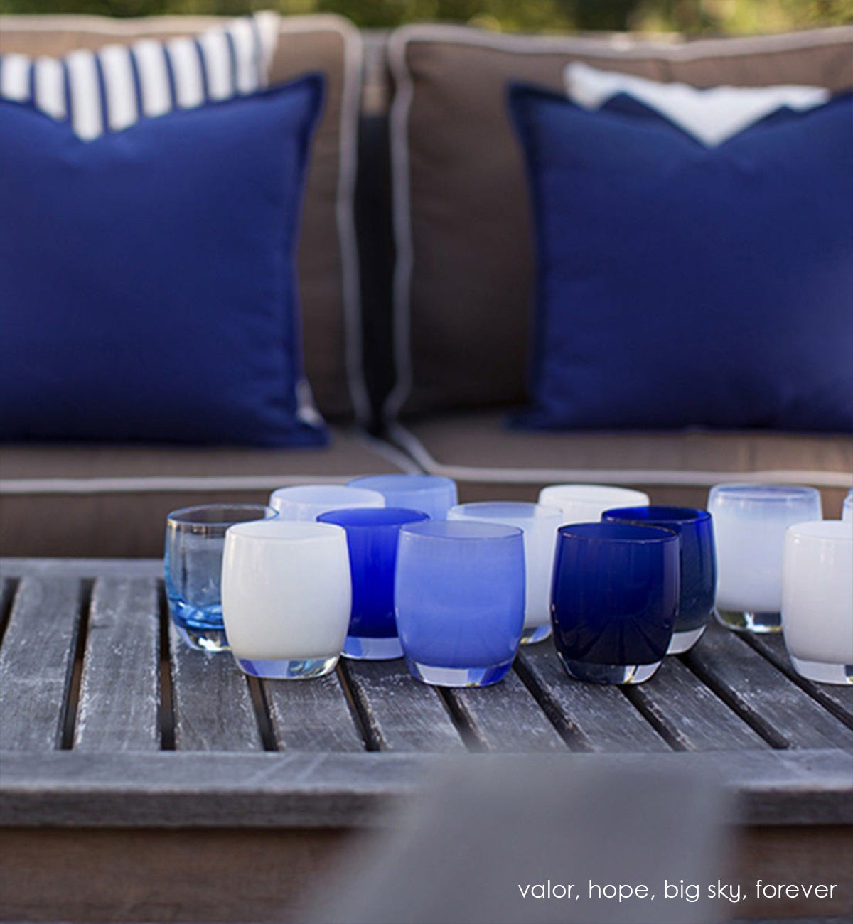 hope pure white hand-blown glass votive candle holder. Paired with valor, big sky, and forever on a wood patio coffee table.