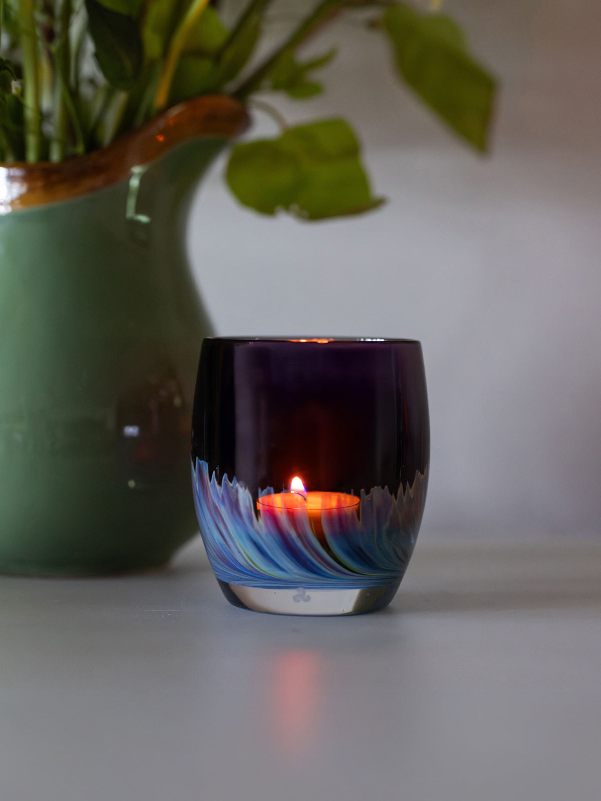 northern lights | purple with blue and green swooshing up from the bottom hand-blown glass votive with green vase with yellow flowers