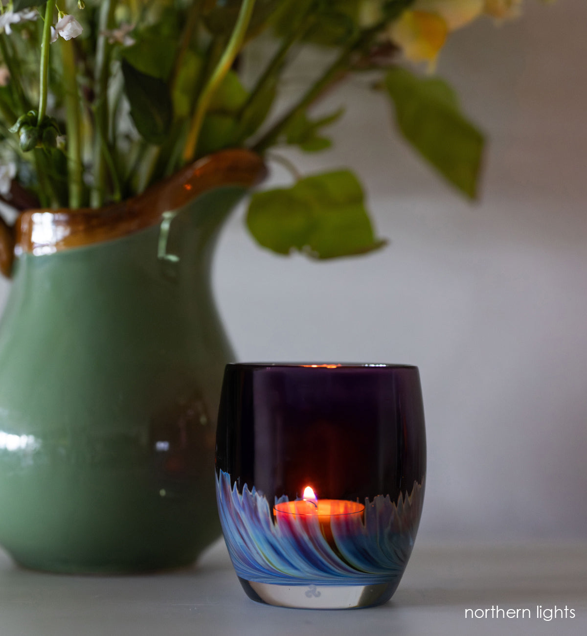 northern lights | purple with blue and green swooshing up from the bottom hand-blown glass votive with green vase with yellow flowers