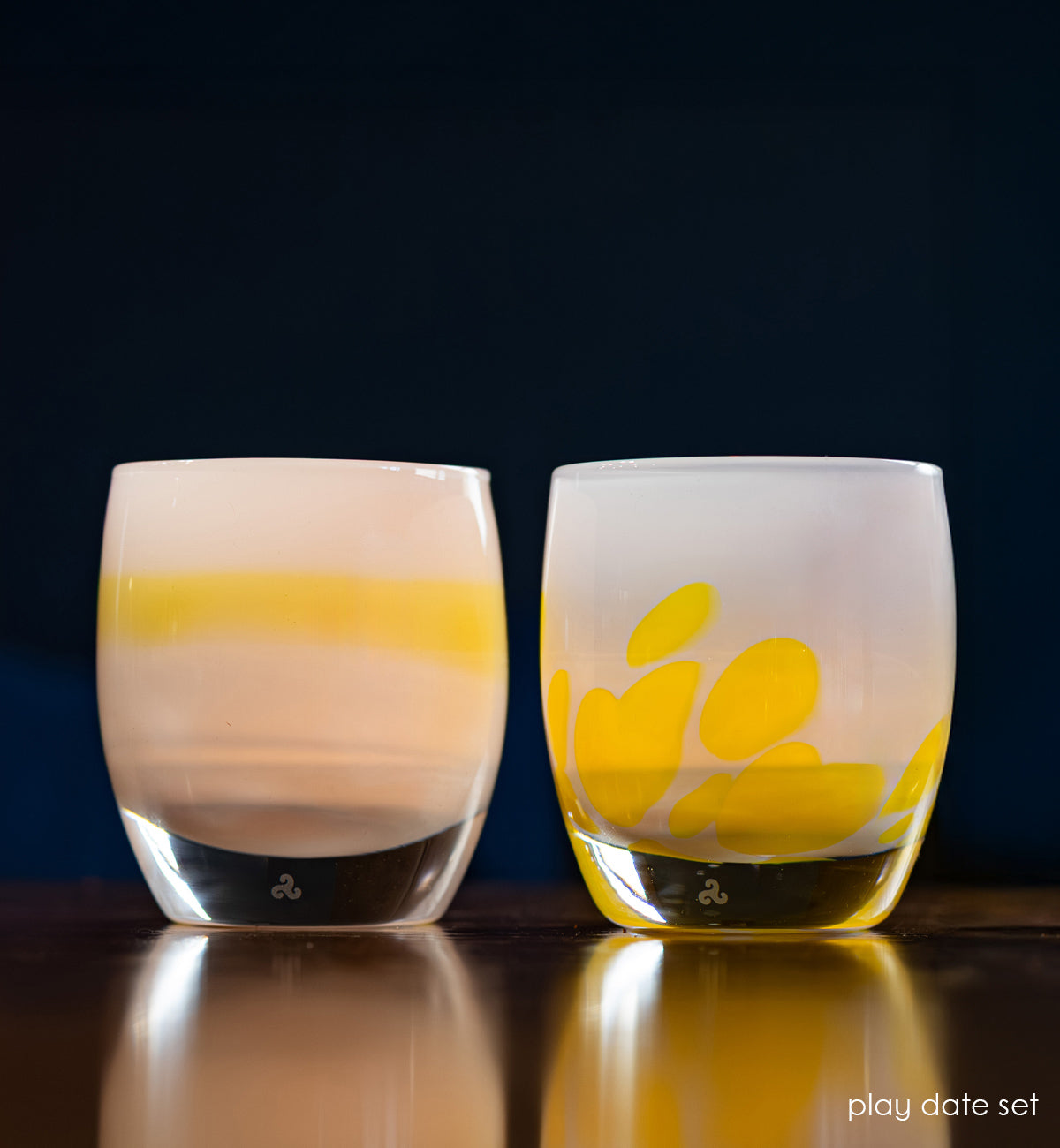light blue and yellow chartreuse and light blue with yellow petals set of two hand-crafted glass votive candle holders lit with dark blue background