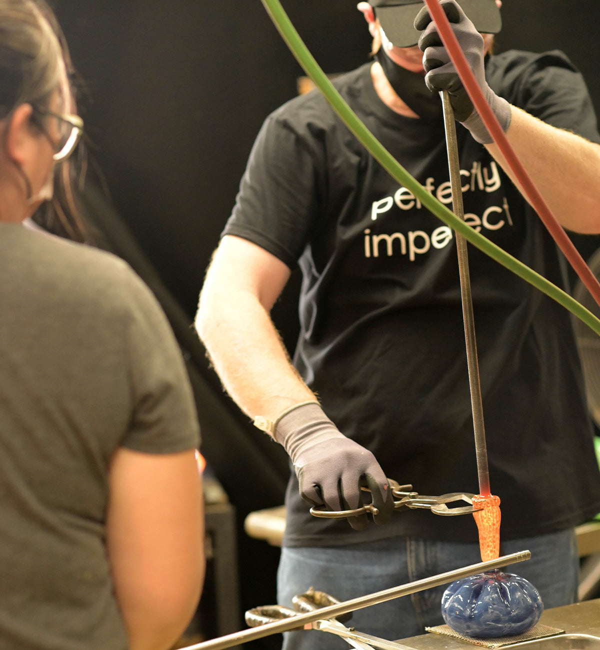 a glassblower and customer created a beautiful hand-blown glass pumpkin together in a glassybaby hot shop.