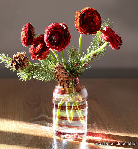 clear handblown glass bloomette with red twisted around it. with red flowers in vase. 